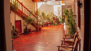 Habitación triple estándar, balcón, vista al patio | Área de sala de estar