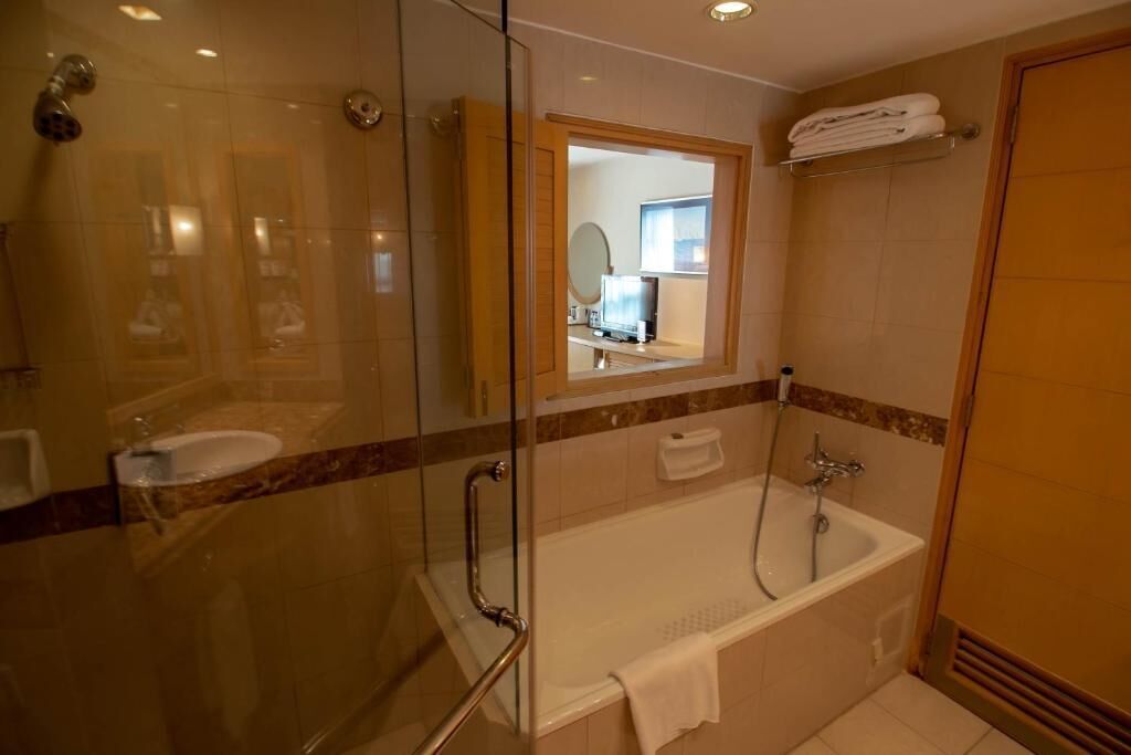 Ein modernes Badezimmer mit Duschkabine aus Glas, einer Badewanne und einem Waschbecken.