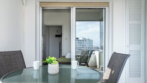 A round glass table with two chairs, a potted plant, and two white mugs on the balcony. - Bastia - Skyline 1-BR Apt in Nicosia (Nicosia)