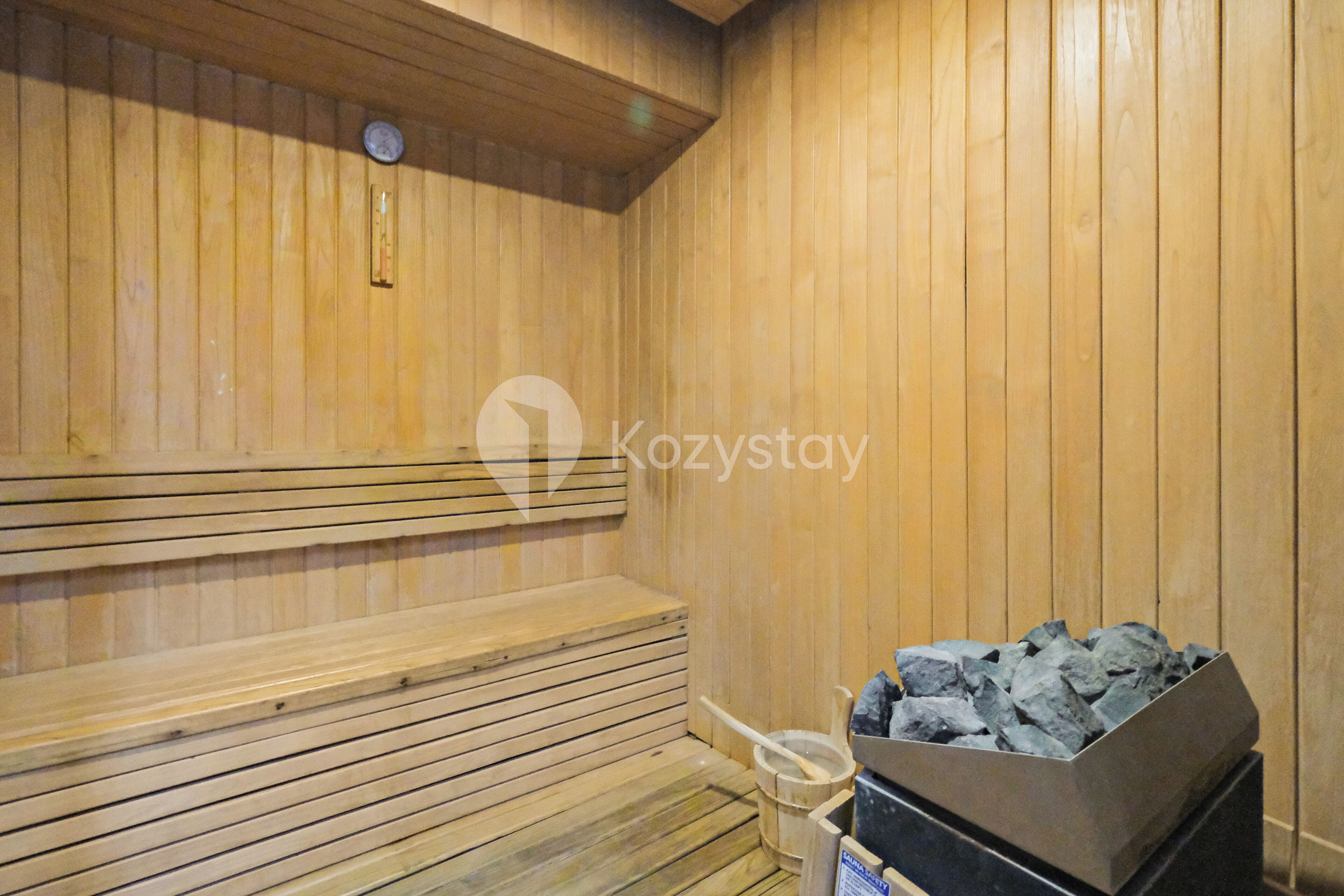 Eine Holzsauna mit Bänken und einem Steinkamin.
