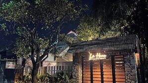 A nighttime view of a building with a sign reading "Le Home." - Lá Home (Hue)