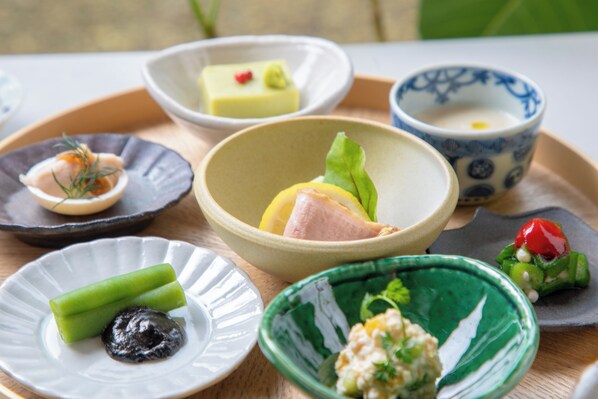 A variety of dishes on a tray, including a bowl with a yellow dessert, a bowl with a white dessert, and a bowl with a green dessert.