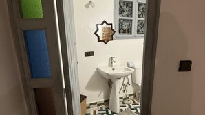 A bathroom with a white sink, a patterned floor, and a decorative star-shaped mirror. - dar fes flower (Fès)