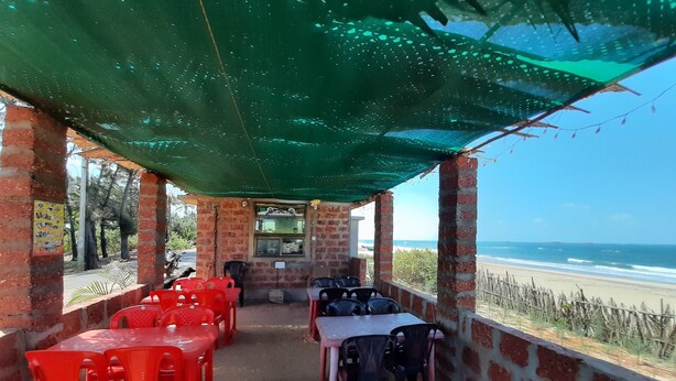 Un café situé en bord de mer, avec une terrasse et vue sur l’océan.