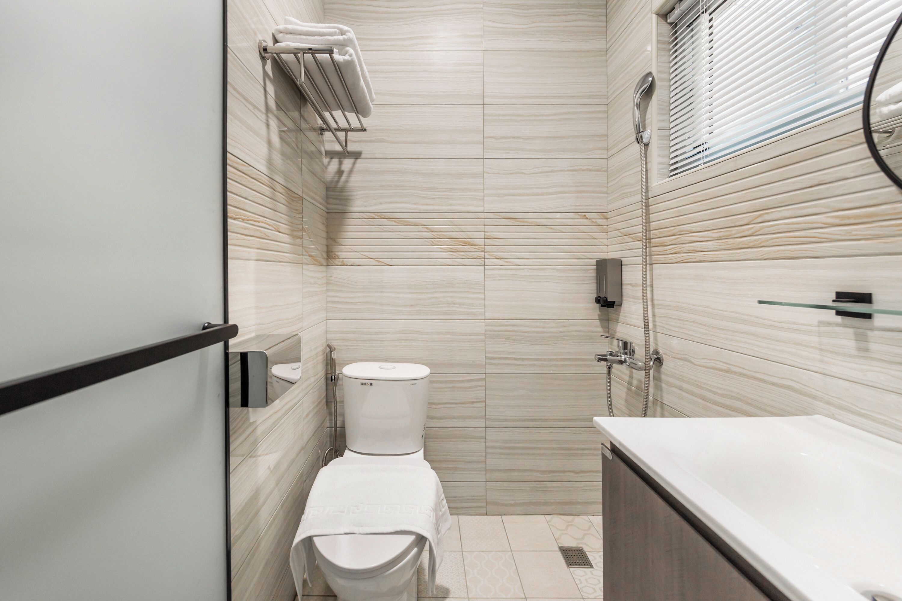 A modern bathroom with a toilet, bidet, and shower.