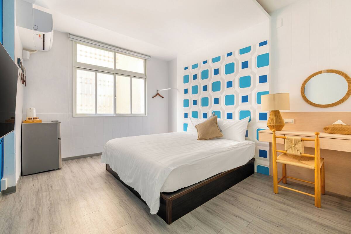 Un dormitorio moderno con una cama, un escritorio y un armario.