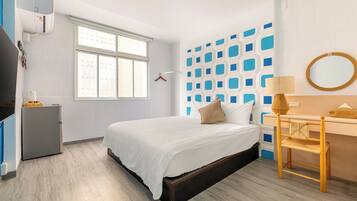 Un dormitorio moderno con una cama, un escritorio y un armario.