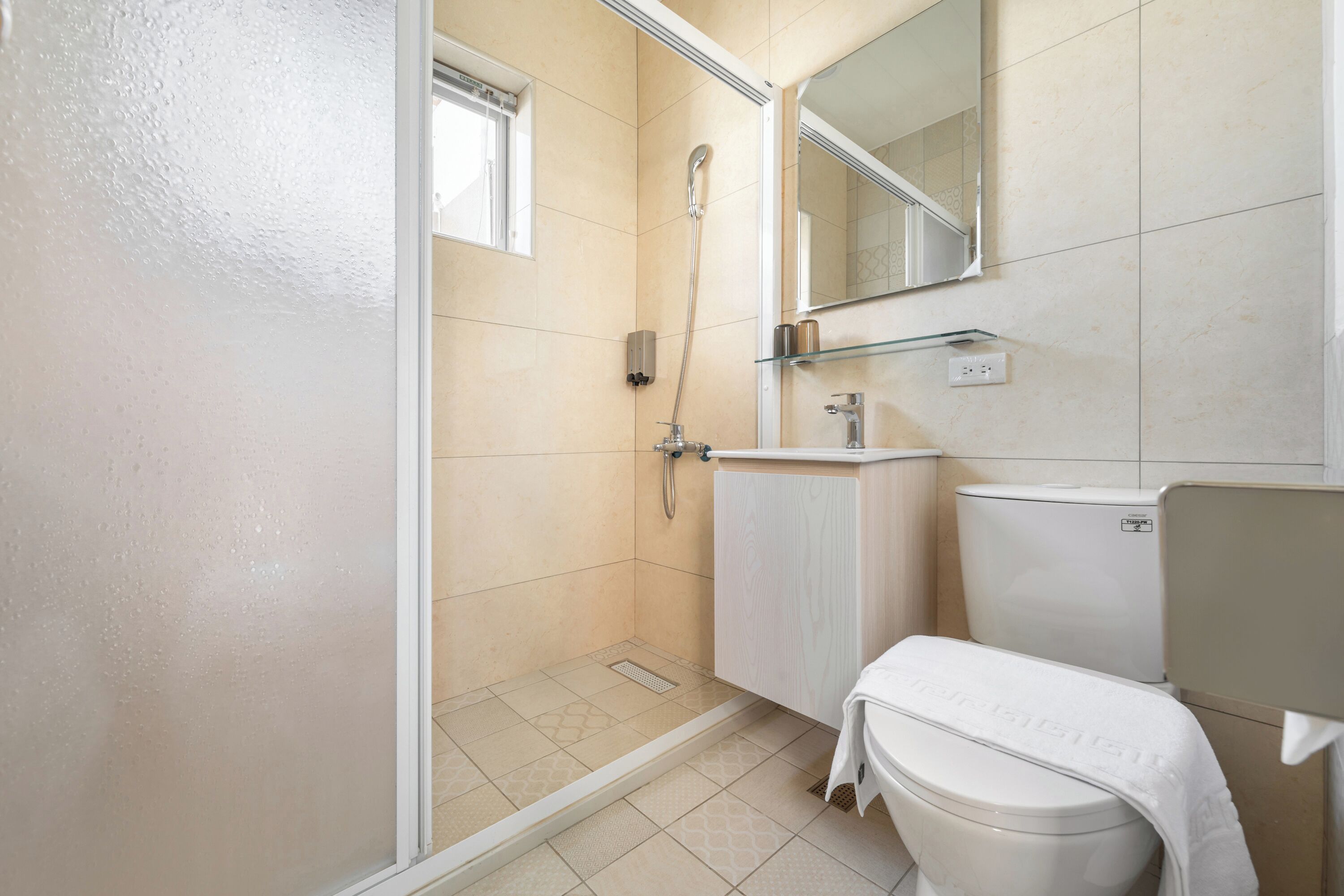 A bathroom with a shower, toilet, and sink.