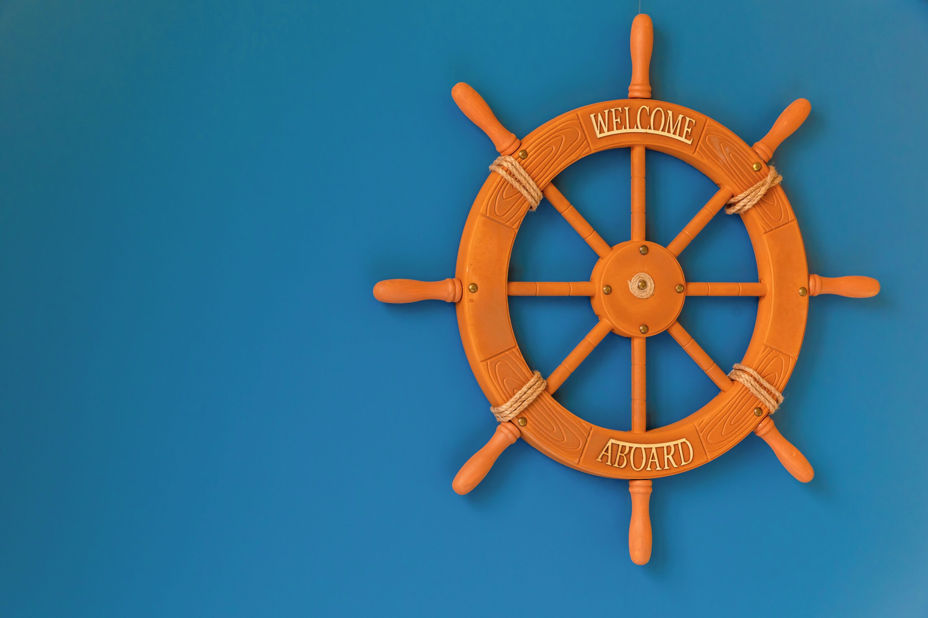 Une roue de navire sur laquelle sont inscrits les mots « BIENVENUE » et « À BORD ».