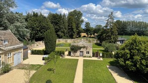 A stone building with a garden, a lawn, and a pathway.