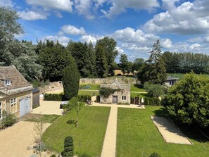 A stone building with a garden, a lawn, and a pathway.