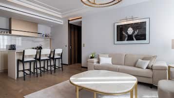 Una sala de estar moderna con una mesa de centro de mármol, un sofá y un comedor con sillas.