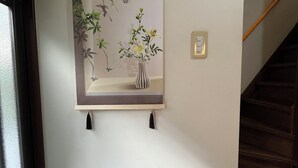 Une œuvre d’art encadrée représentant un vase de fleurs sur un mur.
