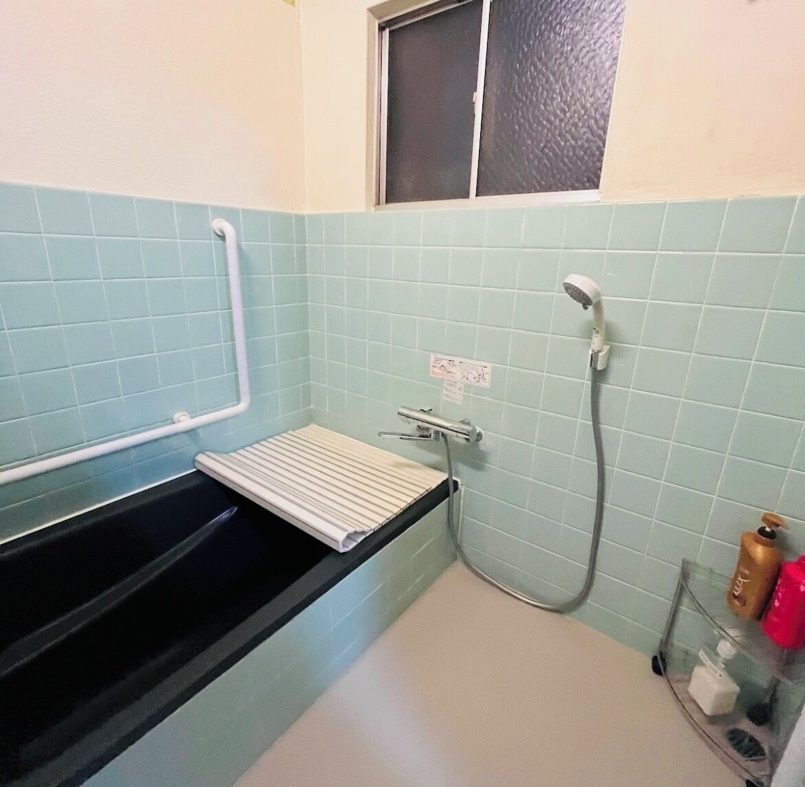 A small bathroom with a shower, a toilet, and a sink.