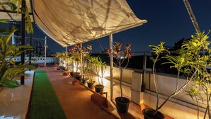 Eine Dachterrasse mit Topfpflanzen und einem pflegeleichten, grünen Rasenbelag.