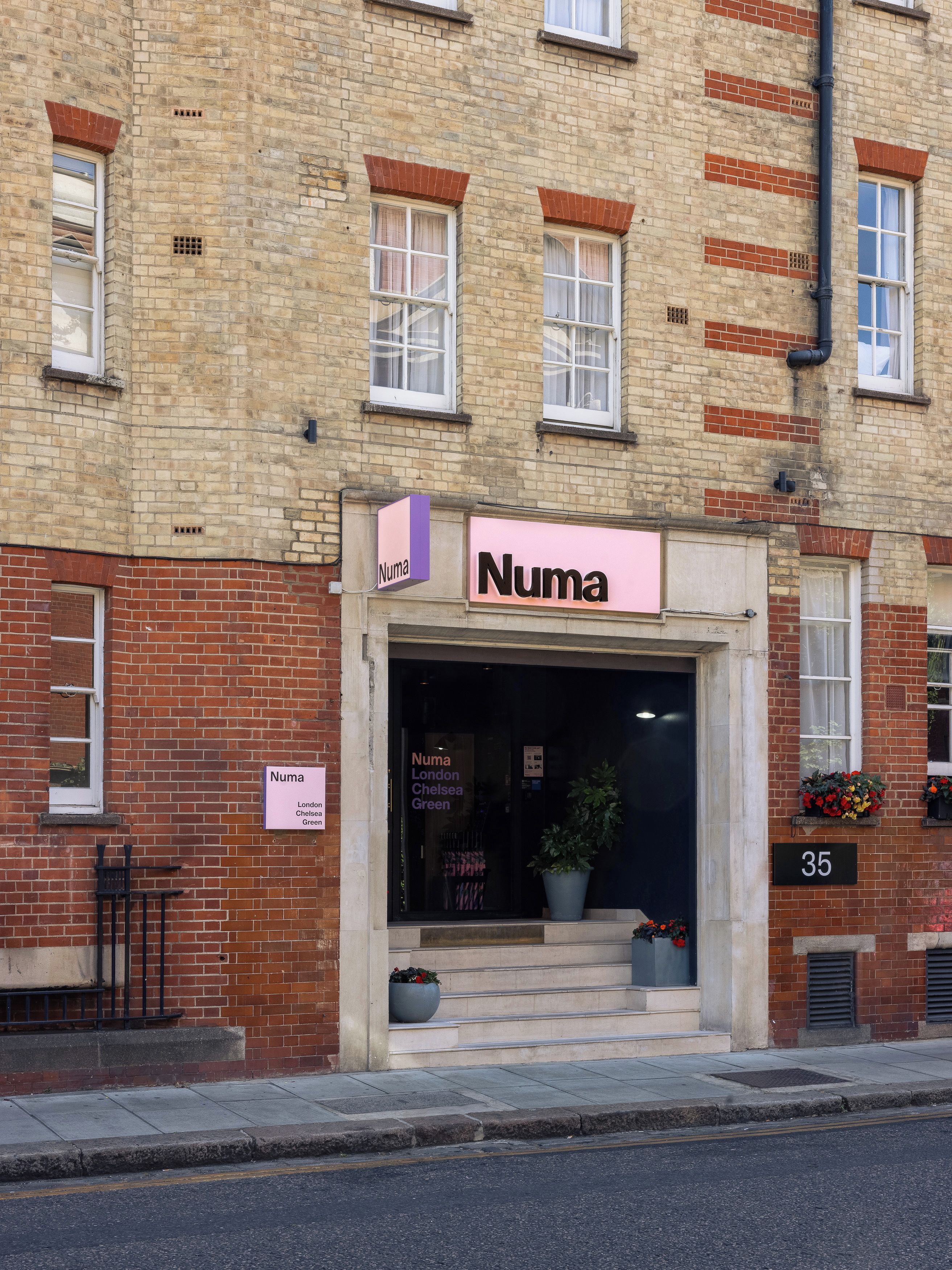 A building with a sign reading 'Numa London Chelsea Green.'