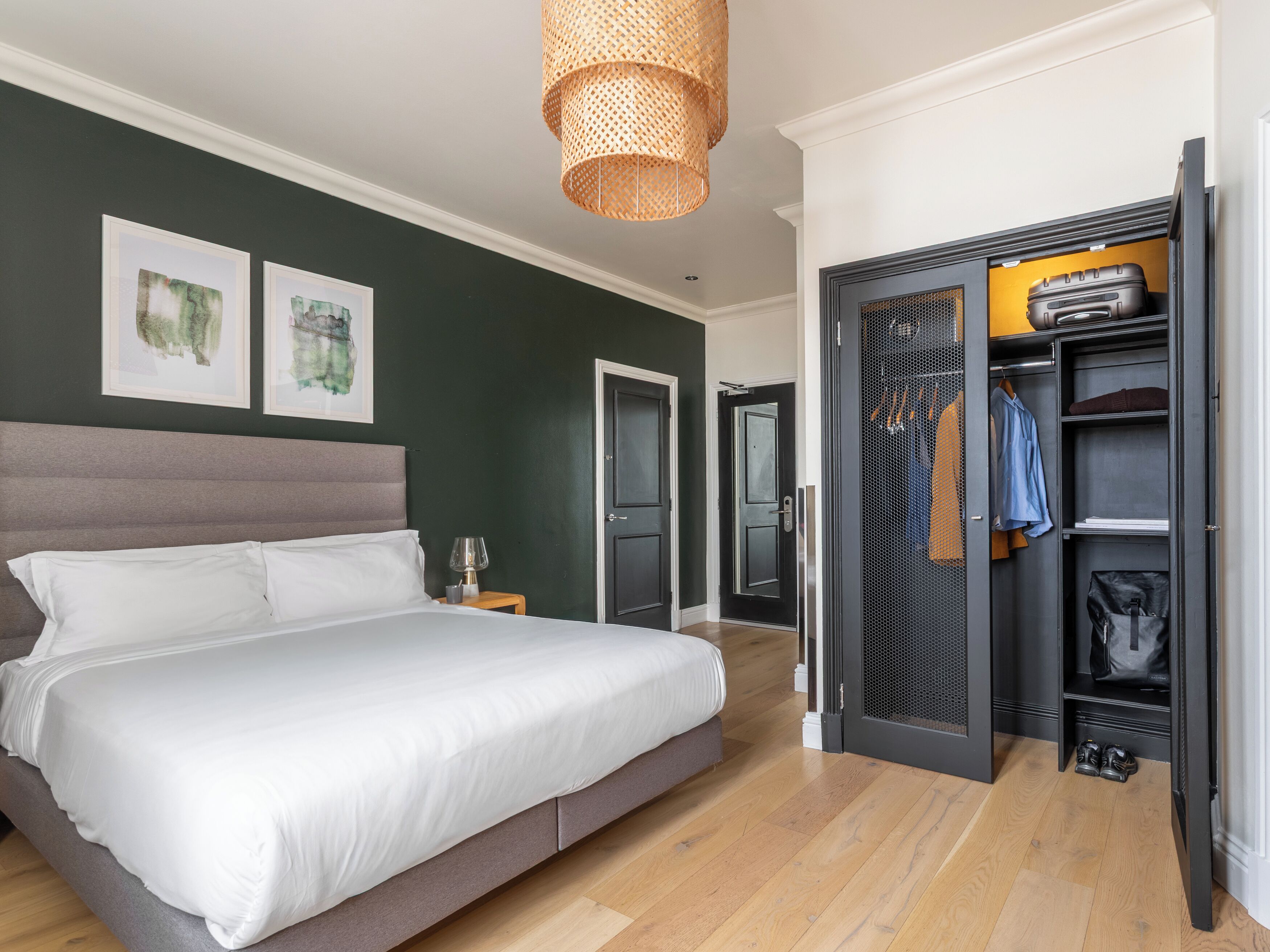 A bedroom with a bed, a wardrobe, and a door leading to another room.