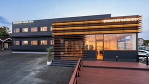 A modern hotel with a flat roof, large windows, and a wooden deck. - SPACEPORT HOTEL OITA (Kunisaki)