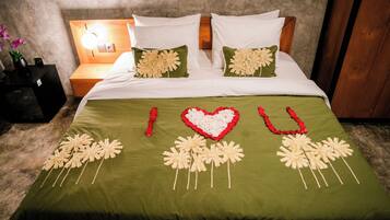 Un llit amb roba de llit verda i adorns florals decoratius.