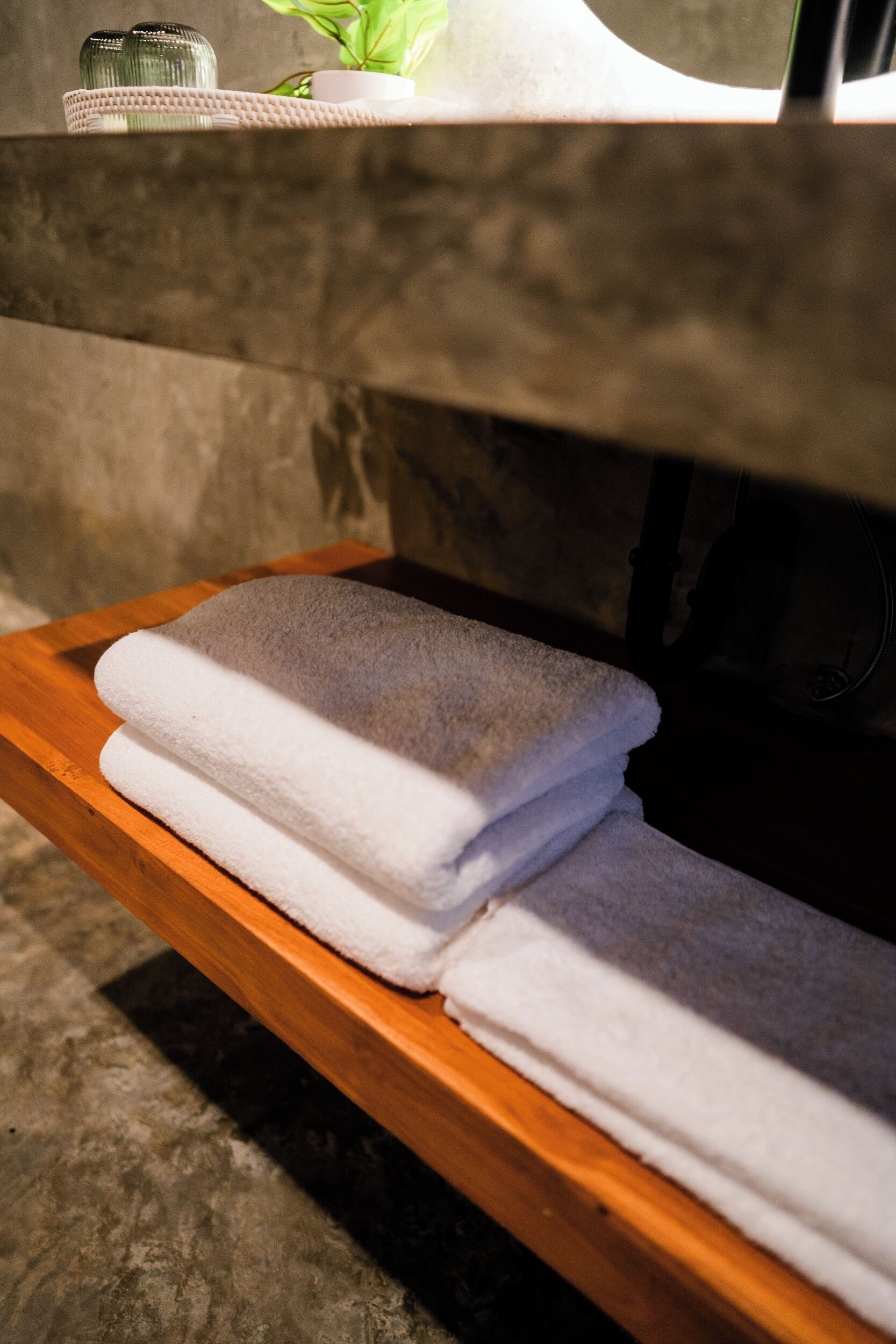 A wooden shelf with folded towels.