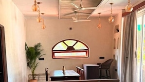 Un rincón acogedor con sofá y sillones, una mesa de centro de madera y un jarrón decorativo.