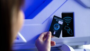 A person holding a card with a "WELCOME" sign and a symbol indicating a power outlet. - HB INN (Hiroshima)