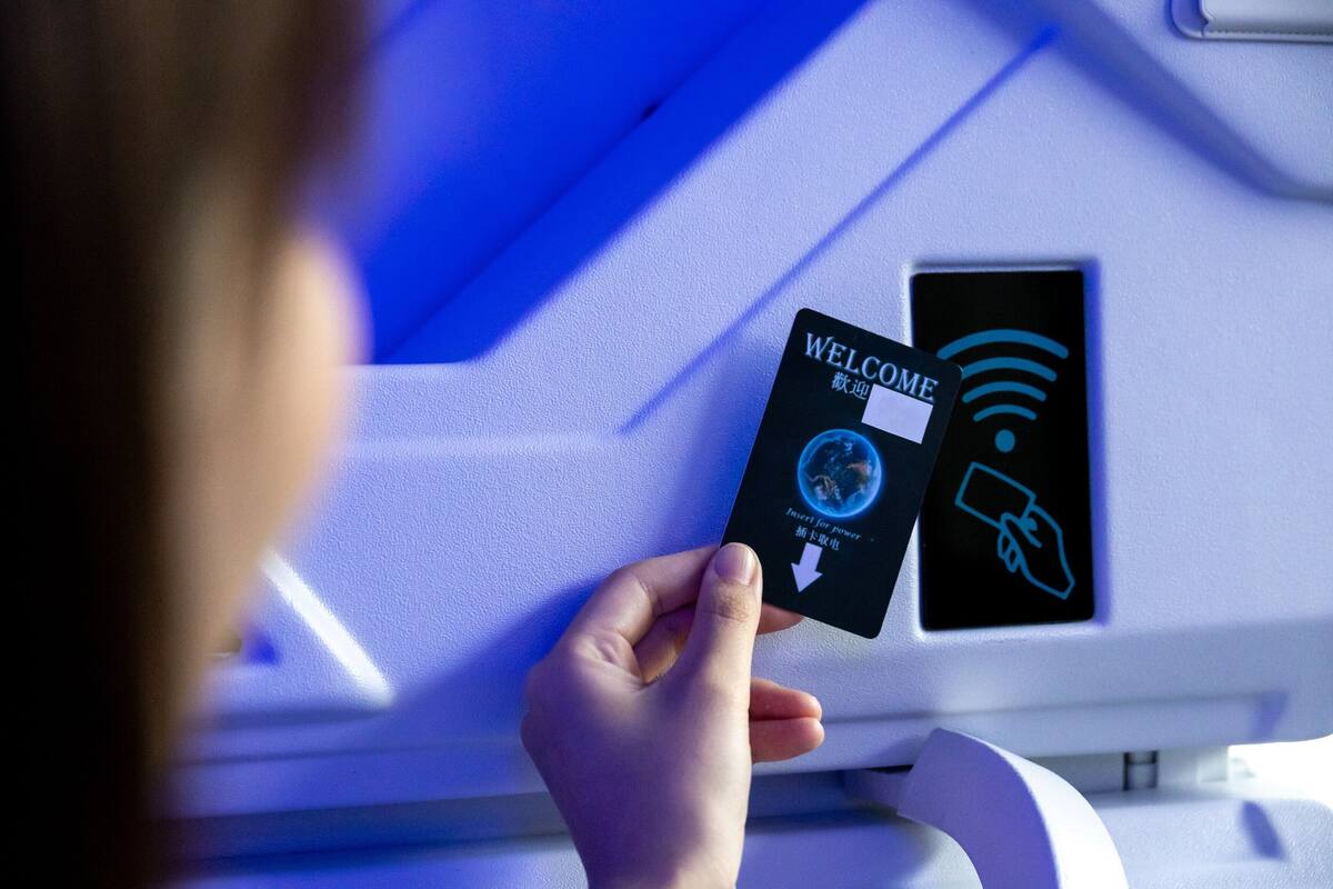A person holding a card with a "WELCOME" sign and a symbol indicating a power outlet.