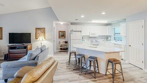 Ein modernes Apartment mit Wohnzimmer, Küche und Essbereich.