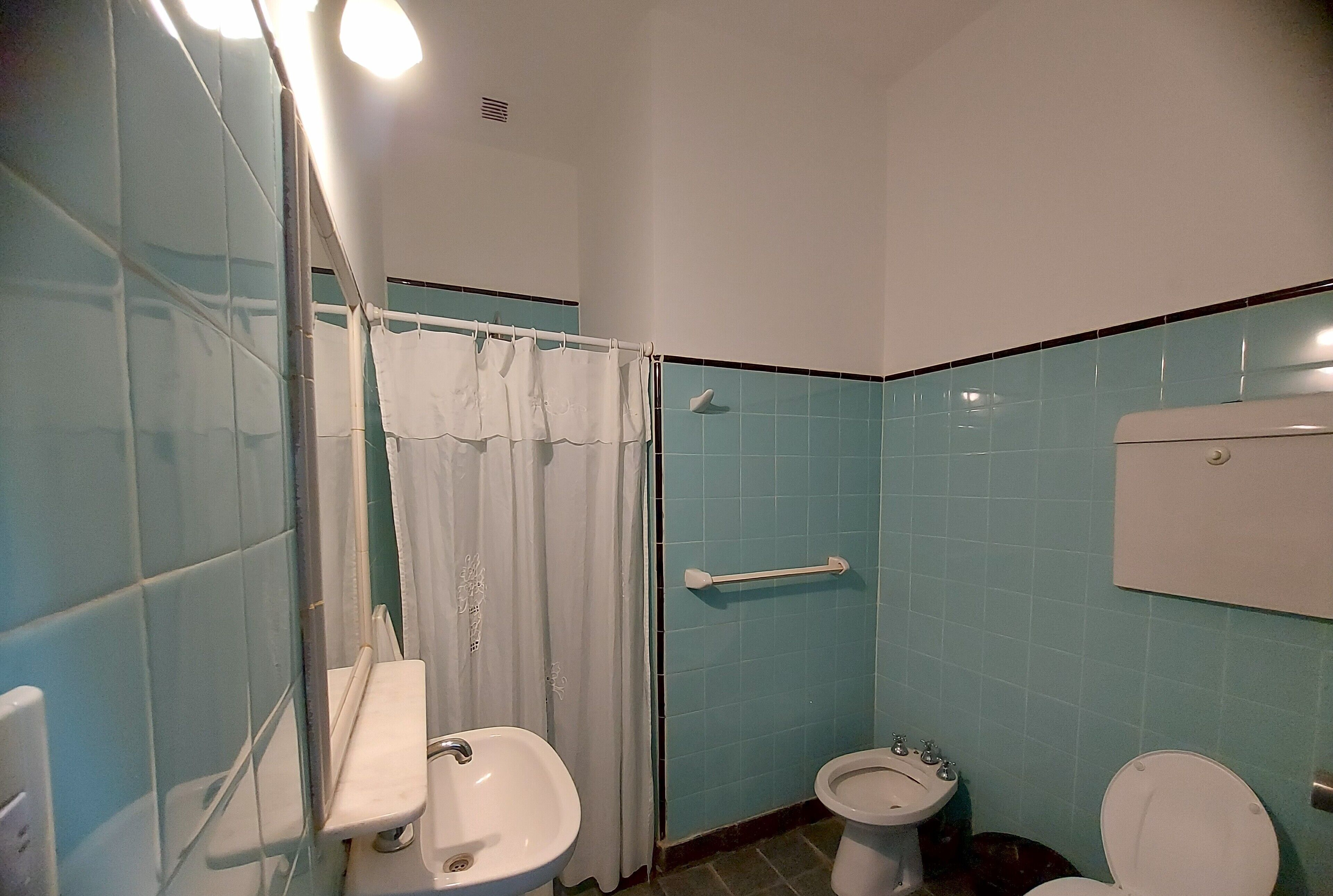 A bathroom with a toilet, bidet, and sink.