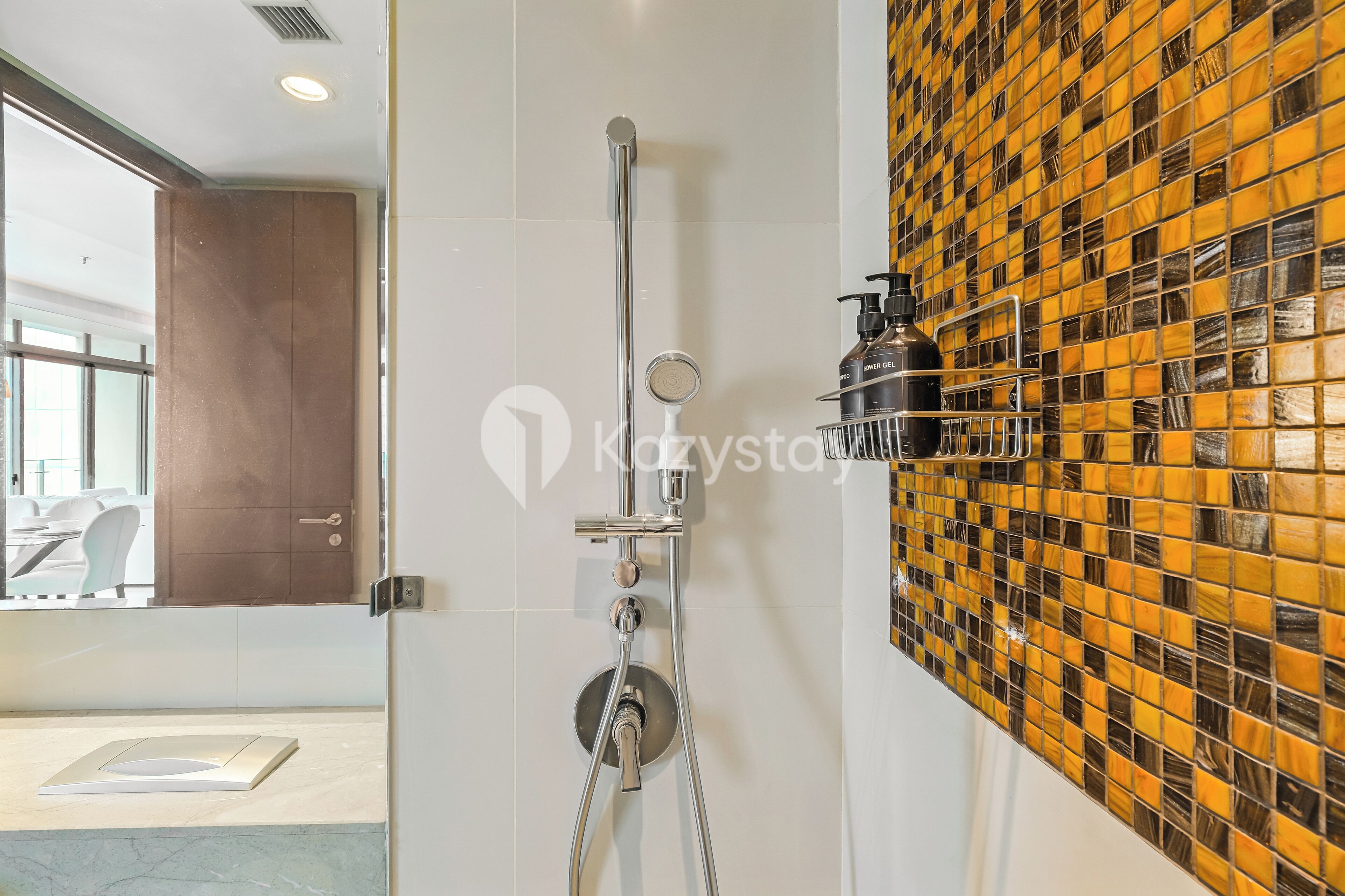 Ein modernes Badezimmer mit Dusche, einer gefliesten Wand und einer Tür zu einem Raum mit weißem Boden und einer Glastrennwand.