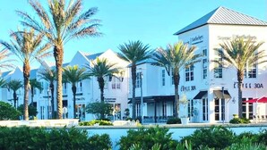 A hotel with a pool, palm trees, and a sign for 'Furniture & Decor'. - Inlet Sands 105 (Panama City Beach)