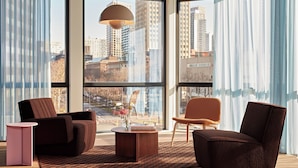 Ein modernes Wohnzimmer mit großen Fenstern, einem runden Couchtisch und zwei Sofas.