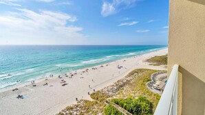 A beach view from a balcony with a clear sky, sandy beach, and ocean. - Emerald Beach 931 (Panama City Beach)