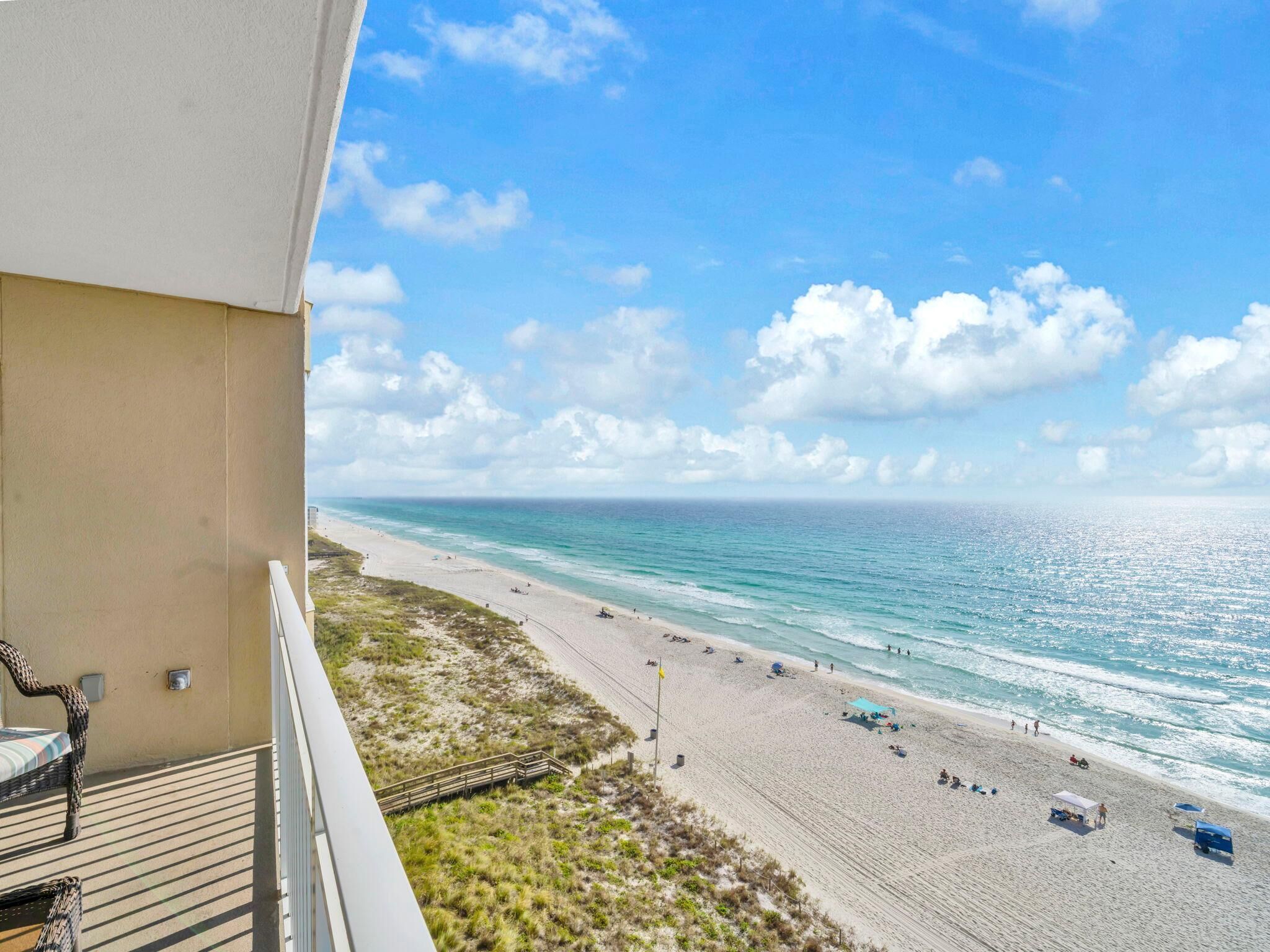 A balcony with a view of a beach and ocean.