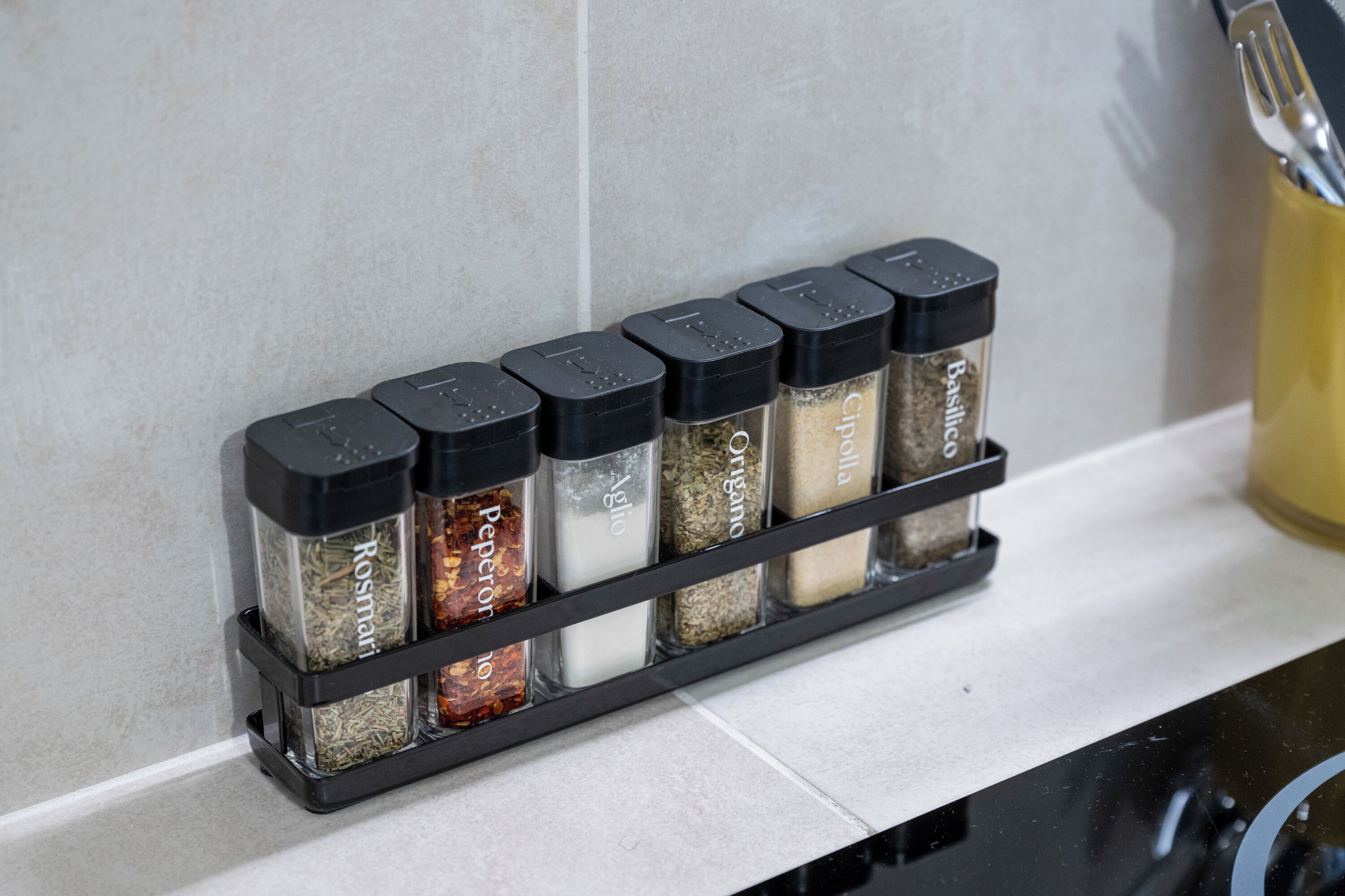 Un mueble especiero con diversas especias sobre una encimera de cocina.