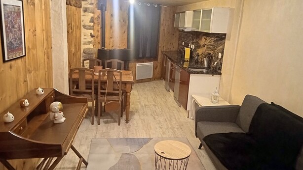 Ein gemütliches Wohnzimmer mit einer Couch und einem Essbereich mit Stühlen und einem Tisch.