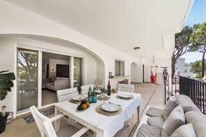 A dining area with a table set for two, a sofa, and a view of the interior. - 'Florida' Apartment with Private Pool, Wi-Fi, and Air Conditioning (Almancil)