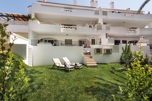 A two-story building with a flat roof, a balcony, and a staircase leading to the upper floor. - 'Florida' Apartment with Private Pool, Wi-Fi, and Air Conditioning (Almancil)