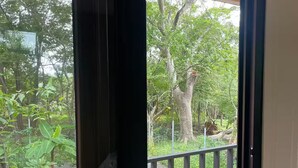 Une vue depuis un balcon doté d’un plafond en bois, d’une rambarde en métal et d’une porte donnant sur l’extérieur.