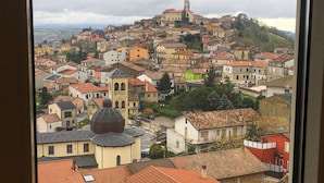 A view of a town with a prominent church on a hill, surrounded by residential buildings. - Belvedere Vallata Affitti Brevi (Vallata)