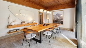 A modern dining area with a wooden table, chairs, and a unique wall art piece. - Casa do Alto da Coutada: Mountain View, Private Pool and Wi-Fi (Ponte de Lima)