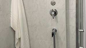 A bathroom with a shower, a towel hanging on the wall, and a toilet paper holder. - LUISA ROOM (Sampieri)