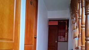 A hallway with wooden doors and a staircase with wooden balusters. - hostal kuntur cusco (Cusco)