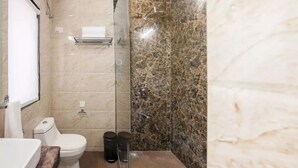 Ein Badezimmer mit Toilette, Dusche und Marmorwand.