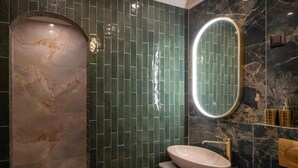 A modern bathroom with a marble vanity, a large mirror, and a shower area. - Pervicacia Lux Studios (Dubrovnik)
