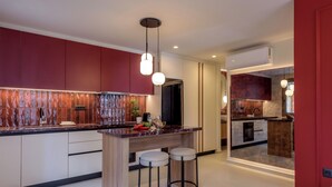A modern kitchen with a central island, bar stools, and pendant lighting. - Mavili Urban Elegance (Heraklion)