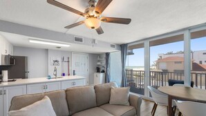 Eine moderne Küche mit Backofen, ein Essbereich mit Tisch und Stühlen, eine Sitzecke und ein Balkon mit Blick auf den Strand.