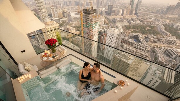 Ein Paar in einer Badewanne mit Blick auf die Stadtlandschaft.