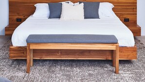 Un dormitorio con cama de madera, ventilador de techo, aire acondicionado y una obra de arte en la pared.