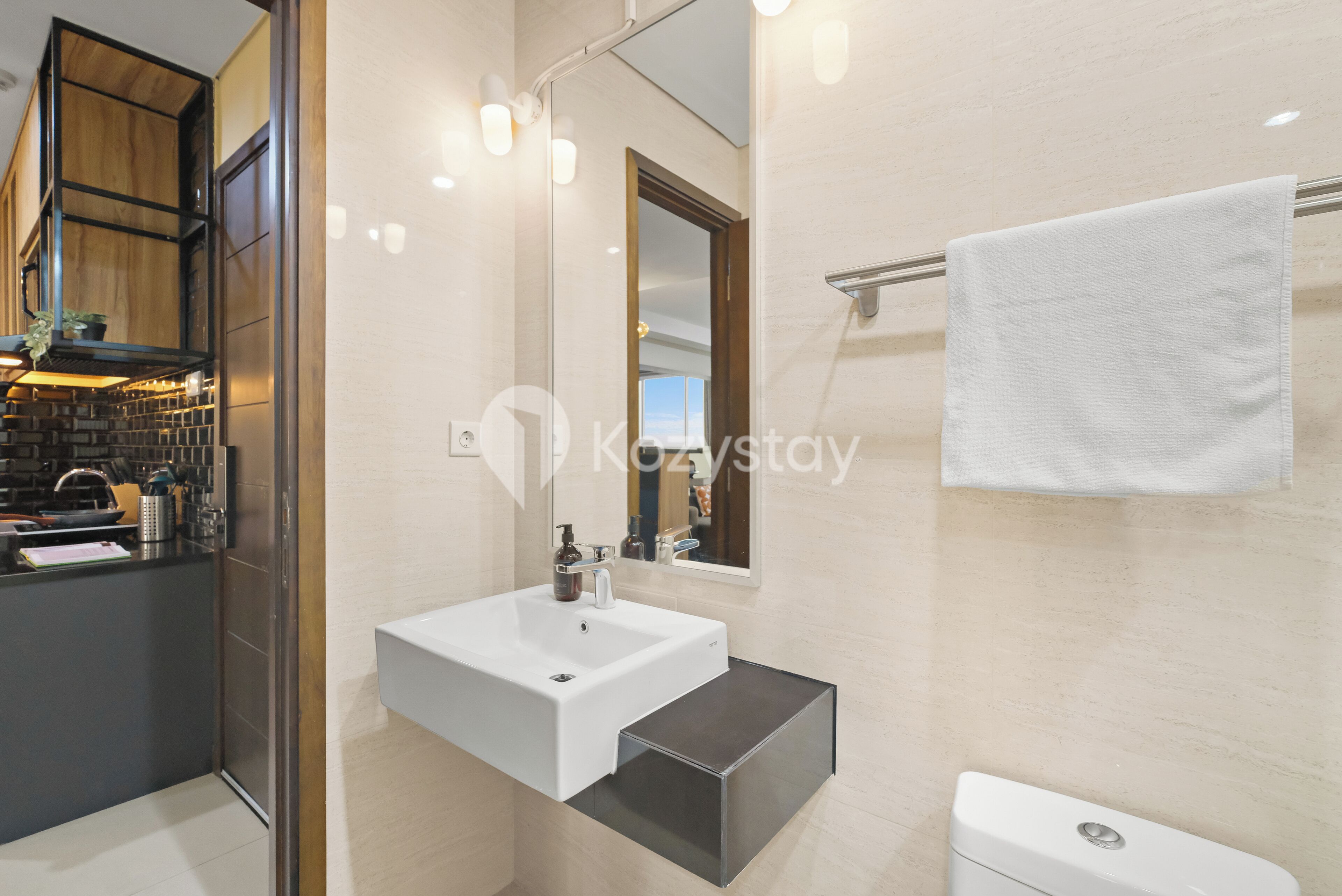 A modern bathroom with a white sink, a mirror, and a towel rack.